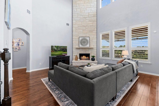 1702 Ambling Trl, Cedar Park, TX 78613 - living room with a towering ceiling, dark wood-style flooring, a fireplace, and arched walkways