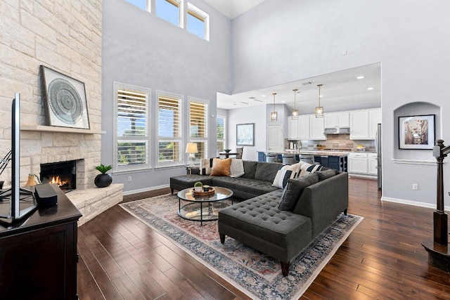 1702 Ambling Trl, Cedar Park, TX 78613 - living area with healthy amount of natural light, a high ceiling, dark wood finished floors, and a stone fireplace