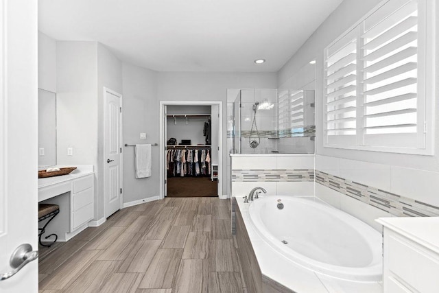 1702 Ambling Trl, Cedar Park, TX 78613 - full bathroom with a garden tub, a shower stall, vanity, a walk in closet, and recessed lighting