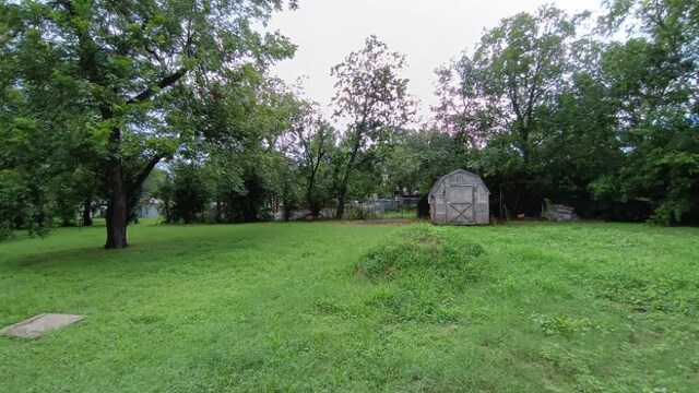 112 W Ila St, Elgin, TX 78621 - view of green lawn with a storage unit and view of scattered trees
