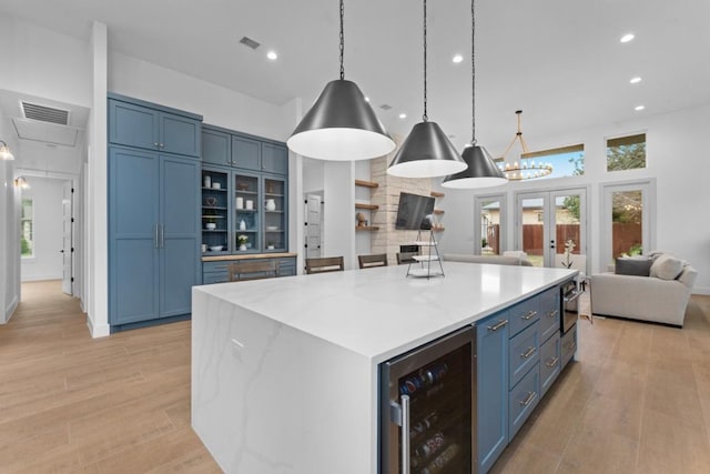 21408 Lakefront Dr, Lago Vista, TX 78645 - kitchen with beverage cooler, open floor plan, blue cabinetry, light wood-style floors, and recessed lighting