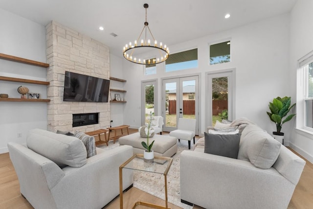 21408 Lakefront Dr, Lago Vista, TX 78645 - living room with a chandelier, a stone fireplace, light wood finished floors, recessed lighting, and a high ceiling