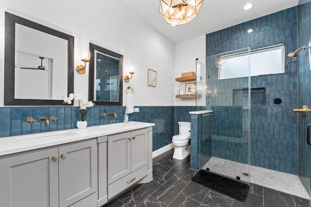 21408 Lakefront Dr, Lago Vista, TX 78645 - bathroom featuring tile walls, double vanity, a stall shower, marble finish flooring, and wainscoting