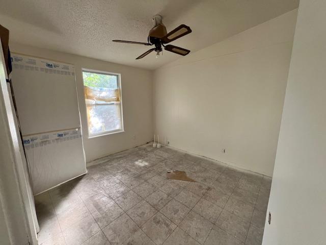 908 Glass Dr, Leander, TX 78641 - unfurnished bedroom with ceiling fan and a textured ceiling