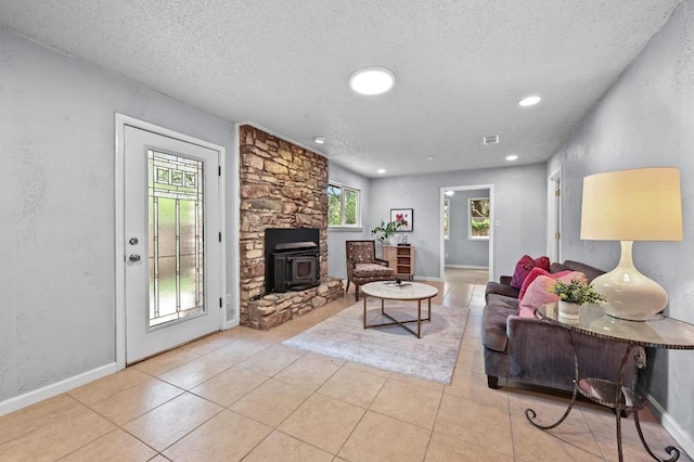 8 Spalding Cir, Wimberley, TX 78676 - tiled living room with a textured ceiling, a textured wall, and a wood stove