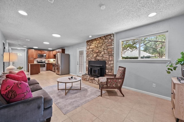 8 Spalding Cir, Wimberley, TX 78676 - living room featuring a wood stove, recessed lighting, a textured ceiling, and light tile patterned floors