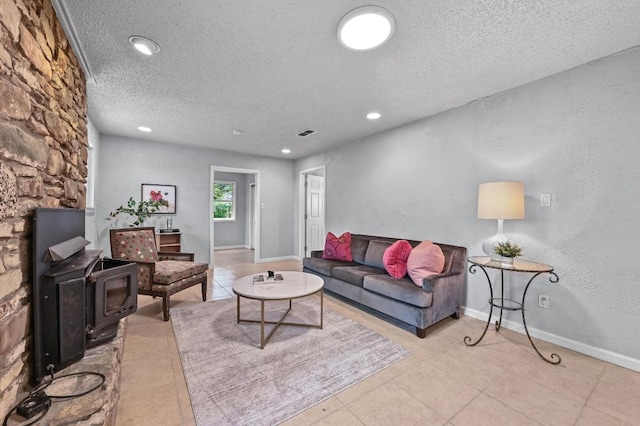 8 Spalding Cir, Wimberley, TX 78676 - living room featuring a textured ceiling, light tile patterned flooring, a wood stove, and recessed lighting