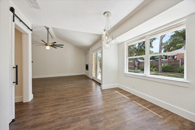2701 Coatbridge Dr, Austin, TX 78745 - unfurnished room with a barn door, dark wood-type flooring, ceiling fan, and vaulted ceiling