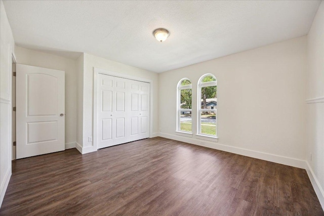 2701 Coatbridge Dr, Austin, TX 78745 - unfurnished bedroom featuring dark wood-type flooring and a closet
