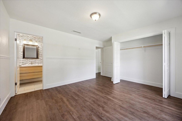 2701 Coatbridge Dr, Austin, TX 78745 - unfurnished bedroom with wood finished floors, a closet, and ensuite bathroom