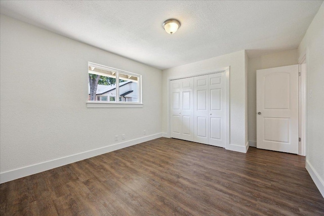 2701 Coatbridge Dr, Austin, TX 78745 - unfurnished bedroom featuring dark wood-type flooring, a closet, and a textured ceiling