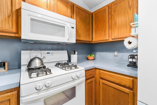 11901 Swearingen Dr Unit 43-I, Austin, TX 78758 - kitchen featuring white appliances, light countertops, and brown cabinets