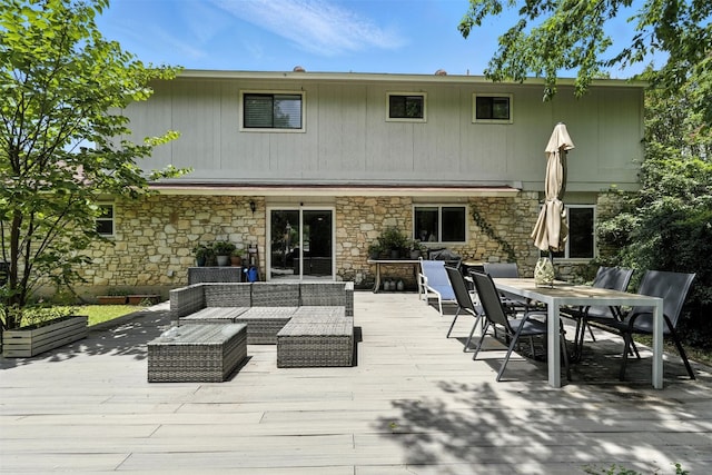7314 Danwood Dr, Austin, TX 78759 - rear view of property featuring stone siding, a deck, outdoor dining area, and outdoor lounge area
