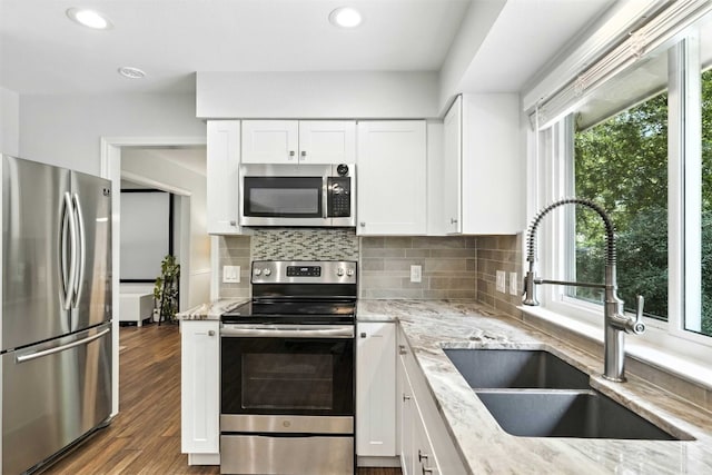 7314 Danwood Dr, Austin, TX 78759 - kitchen with stainless steel appliances, light stone countertops, backsplash, white cabinets, and recessed lighting