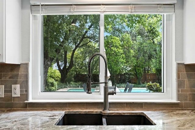 7314 Danwood Dr, Austin, TX 78759 - kitchen view of backsplash, stone counters, and white cabinetry