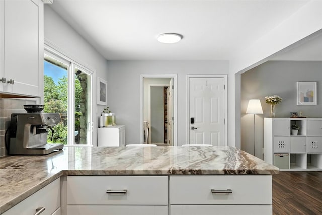 7314 Danwood Dr, Austin, TX 78759 - kitchen with light stone counters, dark wood finished floors, white cabinets, and backsplash