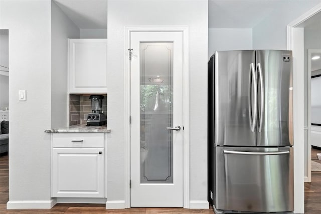 7314 Danwood Dr, Austin, TX 78759 - kitchen featuring freestanding refrigerator, white cabinets, wood finished floors, light stone counters, and backsplash