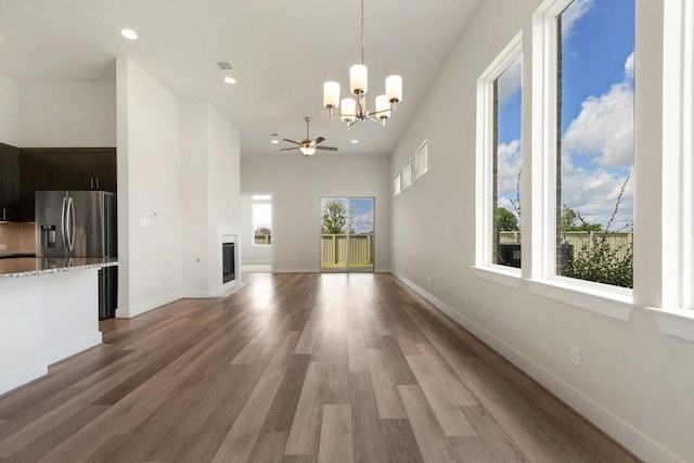 181 Benedum Way, Liberty Hill, TX 78642 - unfurnished living room featuring a chandelier, light wood-style floors, recessed lighting, a ceiling fan, and a glass covered fireplace