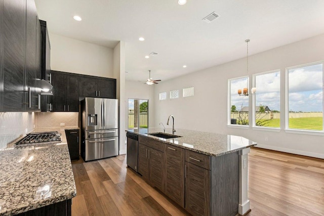 181 Benedum Way, Liberty Hill, TX 78642 - kitchen featuring appliances with stainless steel finishes, light wood-style flooring, tasteful backsplash, recessed lighting, and ceiling fan