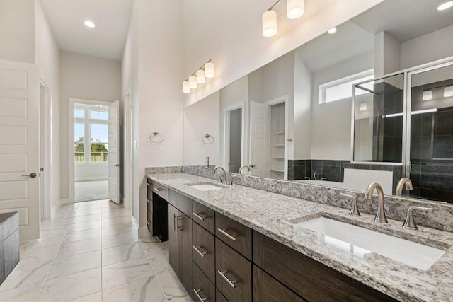 181 Benedum Way, Liberty Hill, TX 78642 - full bath featuring double vanity, recessed lighting, marble look tiles, and a stall shower
