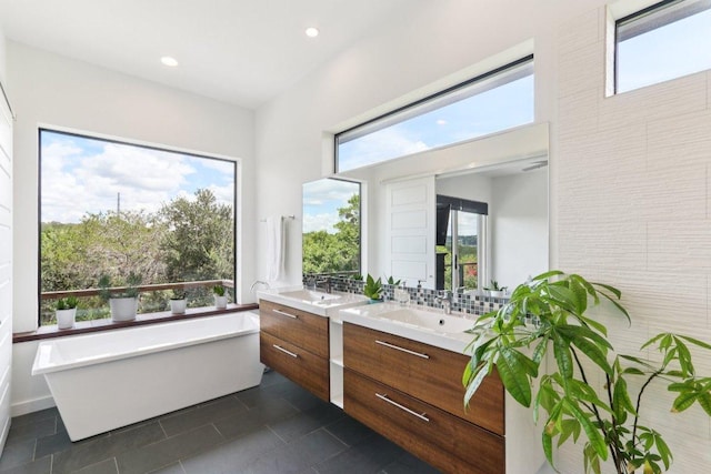 13008 Medina River Way, Austin, TX 78732 - bathroom featuring vanity, a freestanding bath, tile patterned floors, and recessed lighting