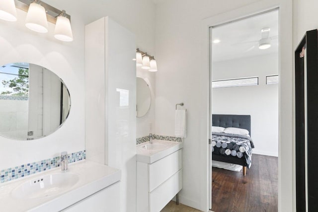 13008 Medina River Way, Austin, TX 78732 - full bathroom with wood finished floors, two vanities, ensuite bathroom, and tasteful backsplash