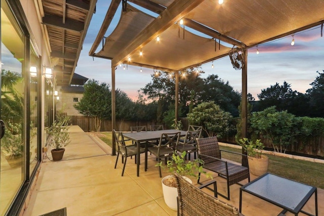 13008 Medina River Way, Austin, TX 78732 - patio terrace at dusk featuring outdoor dining area, a fenced backyard, and a patio
