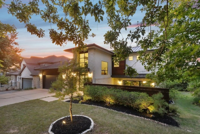 13008 Medina River Way, Austin, TX 78732 - contemporary home featuring a standing seam roof, a metal roof, concrete driveway, and stone siding