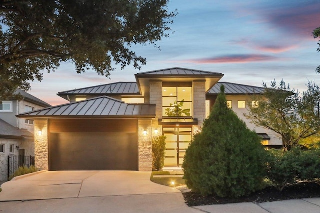 13008 Medina River Way, Austin, TX 78732 - view of front of property featuring a standing seam roof, a metal roof, stone siding, and driveway