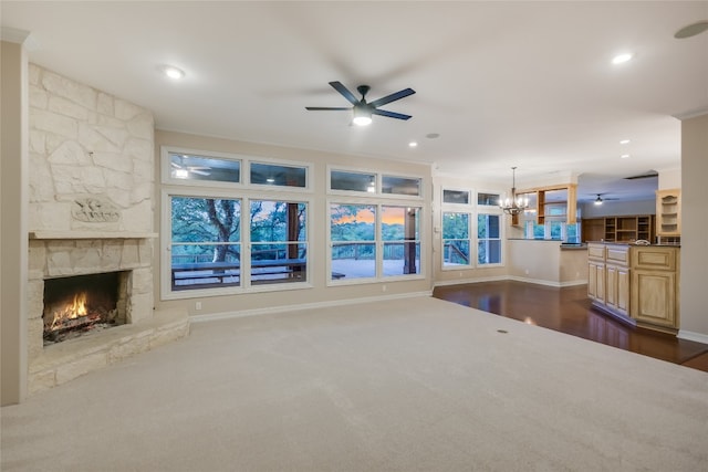 24205 State Highway 71 W, Spicewood, TX 78669 - living area featuring a ceiling fan, a fireplace, a chandelier, dark carpet, and ornamental molding