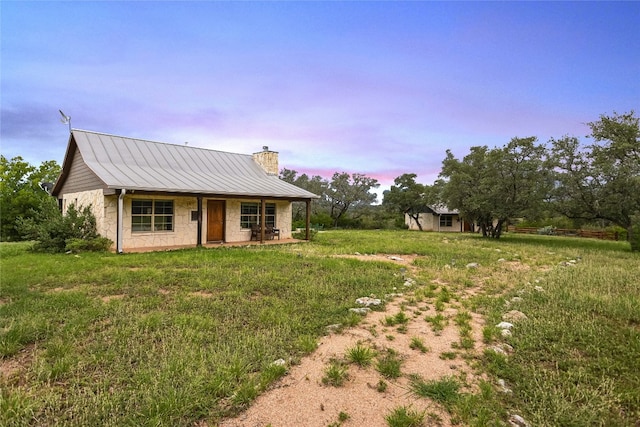 24205 State Highway 71 W, Spicewood, TX 78669 - view of front of home with a chimney, a metal roof, a porch, and stone siding