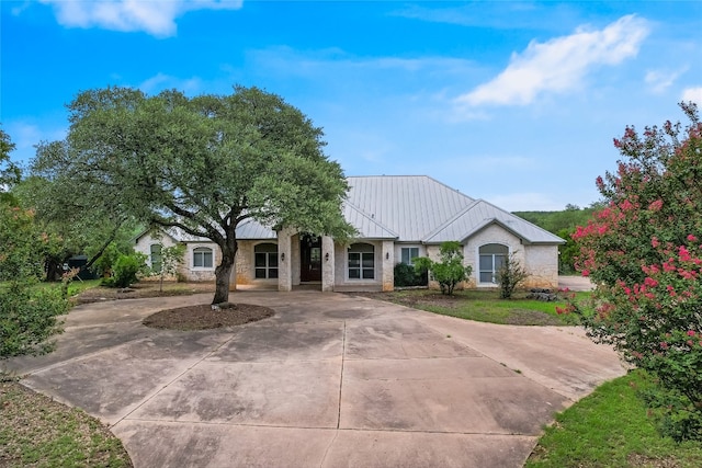 24205 State Highway 71 W, Spicewood, TX 78669 - single story home featuring a standing seam roof, a metal roof, stone siding, and curved driveway