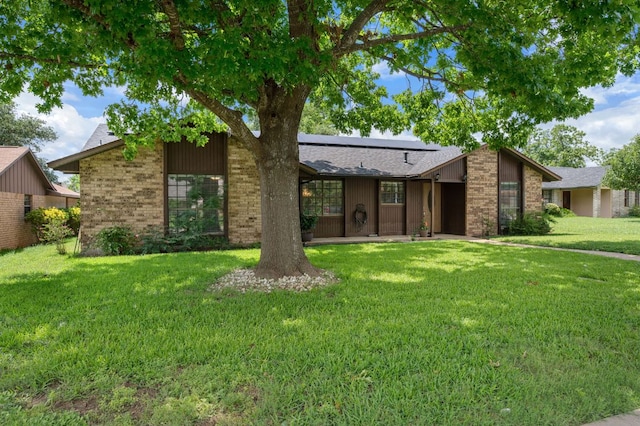 4310 Ponderosa Ln, Temple, TX 76502 - mid-century home with roof mounted solar panels, brick siding, a front yard, and roof with shingles