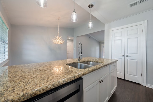 4310 Ponderosa Ln, Temple, TX 76502 - kitchen with dark wood-style flooring, light stone countertops, white cabinetry, stainless steel dishwasher, and pendant lighting