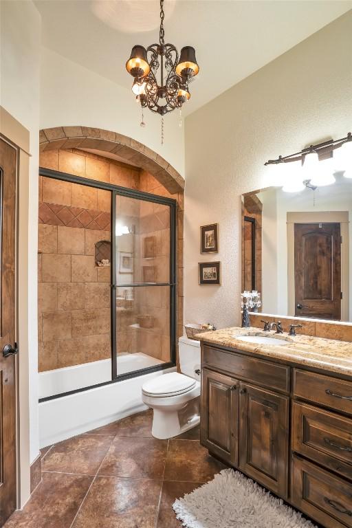 601 Strada Luca, Florence, TX 76527 - bathroom with a chandelier, vanity, bath / shower combo with glass door, and tile patterned flooring