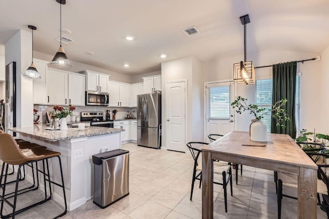 236 Cinnamon Loop, Burnet, TX 78611 - kitchen featuring a peninsula, stainless steel appliances, white cabinetry, light stone counters, and recessed lighting