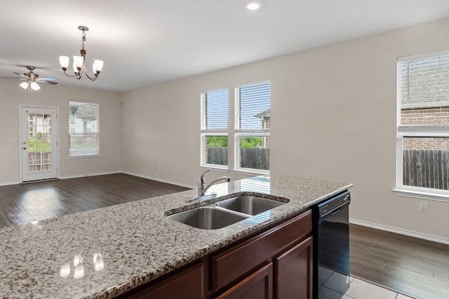 633 Weizenbock Ln, Austin, TX 78728 - kitchen featuring a chandelier, wood finished floors, dishwasher, pendant lighting, and light stone counters