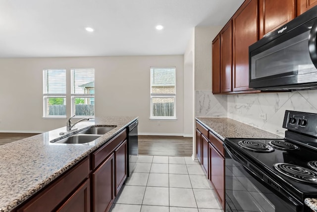 633 Weizenbock Ln, Austin, TX 78728 - kitchen featuring black appliances, healthy amount of natural light, light stone countertops, backsplash, and recessed lighting