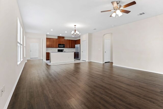 633 Weizenbock Ln, Austin, TX 78728 - unfurnished living room with a chandelier, dark wood-style floors, a ceiling fan, arched walkways, and recessed lighting