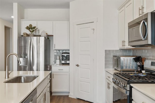 13821 Zuhause Dr, Pflugerville, TX 78660 - kitchen featuring appliances with stainless steel finishes, decorative backsplash, light countertops, and white cabinetry