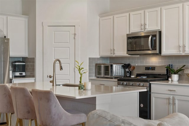 13821 Zuhause Dr, Pflugerville, TX 78660 - kitchen with appliances with stainless steel finishes, decorative backsplash, and white cabinetry
