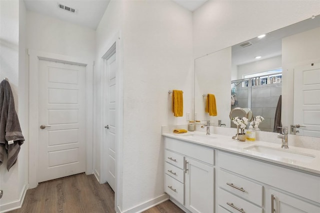 13821 Zuhause Dr, Pflugerville, TX 78660 - bathroom with wood finished floors, double vanity, and a shower stall