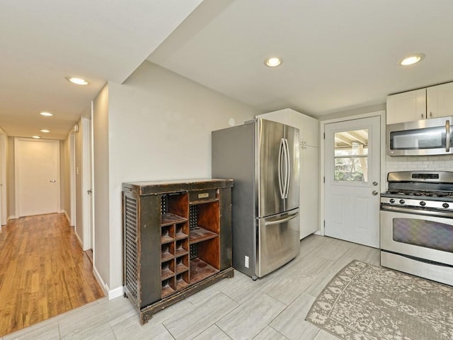 4408 Mount Vernon Dr, Austin, TX 78745 - kitchen featuring stainless steel appliances, white cabinetry, recessed lighting, wood tiled floors, and tasteful backsplash
