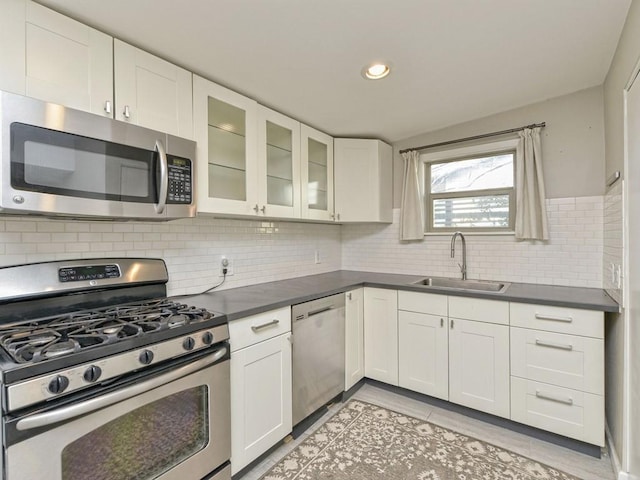 4408 Mount Vernon Dr, Austin, TX 78745 - kitchen featuring appliances with stainless steel finishes, dark countertops, white cabinets, glass insert cabinets, and recessed lighting