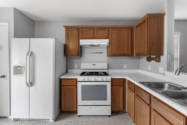 184 Atlantis, Kyle, TX 78640 - kitchen featuring white appliances, light countertops, under cabinet range hood, brown cabinets, and light floors