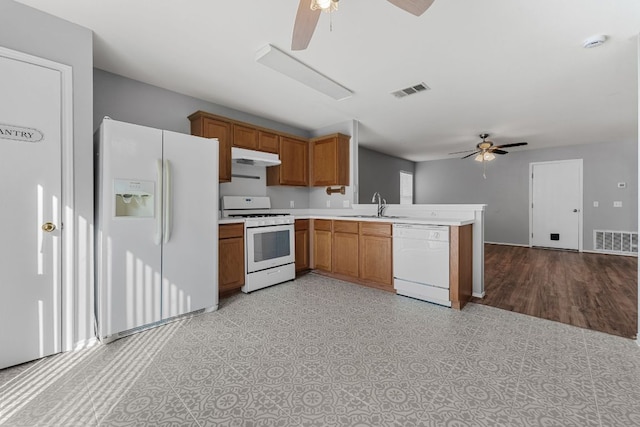184 Atlantis, Kyle, TX 78640 - kitchen with ceiling fan, white appliances, a peninsula, brown cabinetry, and light countertops