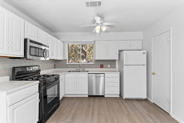 500 Honeysuckle Dr, Cedar Park, TX 78613 - kitchen with stainless steel appliances, light wood-style floors, tasteful backsplash, white cabinets, and a textured ceiling