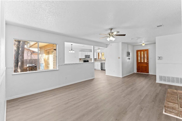 500 Honeysuckle Dr, Cedar Park, TX 78613 - unfurnished living room with a textured ceiling, ceiling fan, and wood finished floors