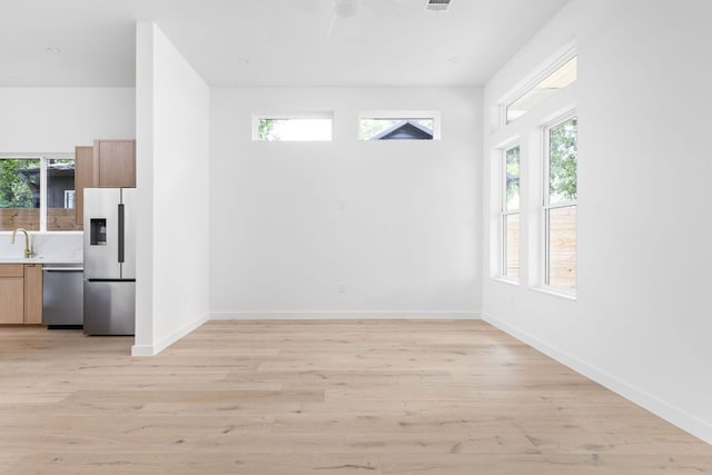 2917 Lyons Rd Unit 1, Austin, TX 78702 - unfurnished dining area featuring light wood-type flooring and baseboards