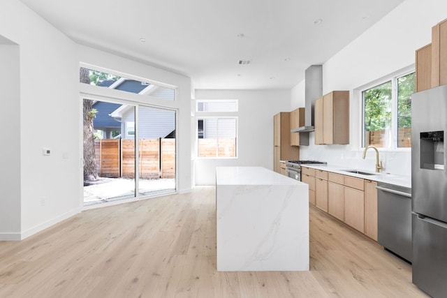2917 Lyons Rd Unit 1, Austin, TX 78702 - kitchen featuring stainless steel appliances, a kitchen island, modern cabinets, wall chimney exhaust hood, and light stone counters